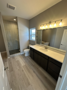 A newly installed bathroom vanity, mirror, and shower by Harpe Development LLC in Kenosha, WI.