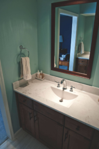 A newly installed bathroom vanity with a sink, faucet, and mirror by Glen E Stuckel Builder LLC in Louisville, KY.