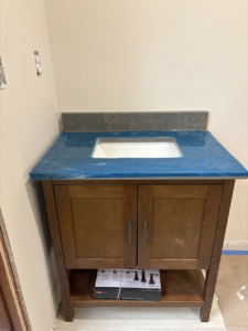 New bathroom vanity with sink cutout and blue-wrapped countertop installed by Capitol Construction and Roofing LLC in Raleigh, NC