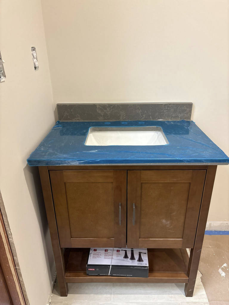 New bathroom vanity with sink cutout and blue-wrapped countertop installed by Capitol Construction and Roofing LLC in Raleigh, NC