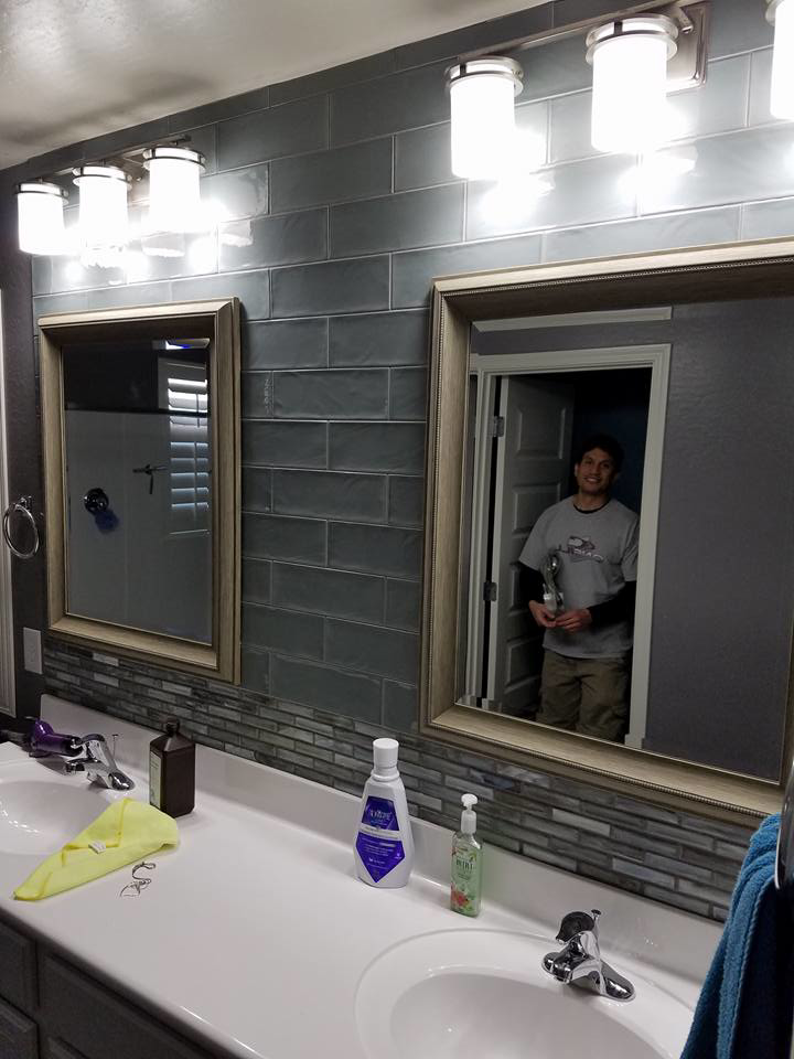 A bathroom vanity with a newly installed tile backsplash, mirrors, and lighting by Clayton Family Tile, LLC in Chandler, AZ