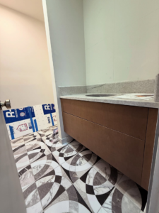 A newly installed bathroom vanity, countertop, and patterned tile floor by Arcadia Building Company in Mesa, AZ.