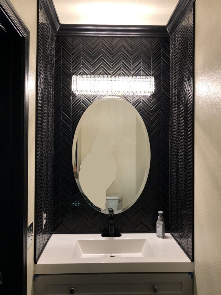 A modern bathroom vanity with black herringbone tile installation by Peak Handyman Services in Las Vegas, NV.