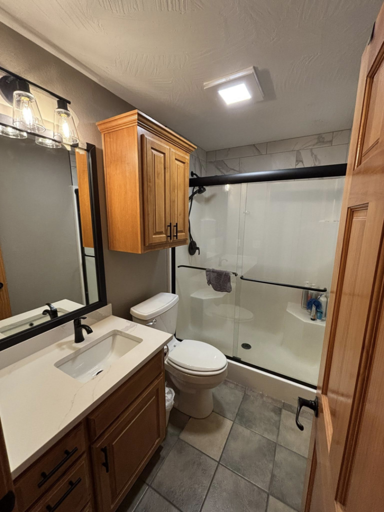A renovated bathroom with new vanity, toilet, and shower installation by Craft Tile Co in Springfield, MO.