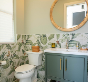 A newly installed bathroom vanity, toilet, mirror, and decorative wall tiles by FITZ Construction in Kenner, LA.