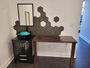 A custom bathroom vanity featuring a blue vessel sink, a wooden countertop, and a modern hexagonal tile backsplash, installed by Huff Consolidated Enterprises LLC in Clarksville, TN.
