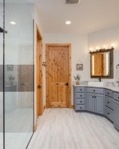 A bathroom remodel with a grey vanity, vessel sink, and glass shower enclosure by Nelson Tile and Stone in Bend, OR.