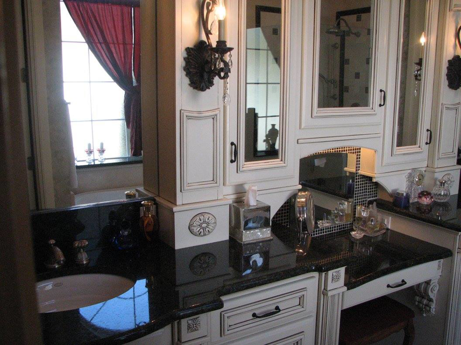 A stylish bathroom vanity featuring white cabinets, a black countertop, and a sink, installed by Metro Contractors & Supply, Inc. in Norman, OK