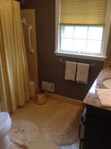 A bathroom showing a vanity, window with blinds, and towel rack by Kingdom Advance Construction in Louisville, KY