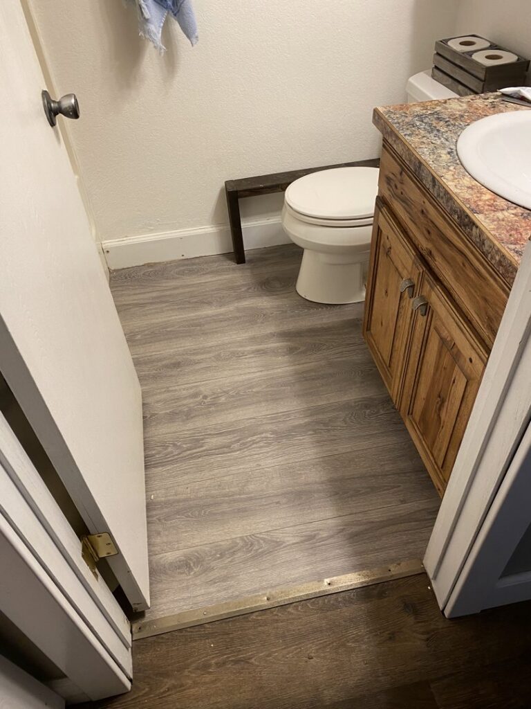 Newly installed vinyl plank flooring in a bathroom, a handyman service completed by No Delay SVCS in Pocatello, ID.