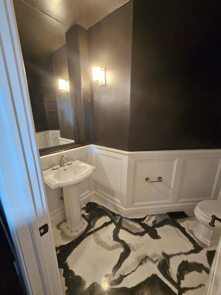 A renovated bathroom with new wainscoting, pedestal sink, and patterned floor by Blue Collar Service Pros in Aurora, CO.