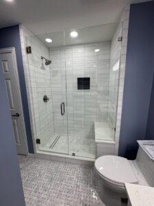 A newly renovated bathroom featuring a walk-in shower with white subway tiles and a built-in bench by Home Platinum Services, LLC in Plano, TX