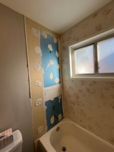 Bathroom wall undergoing repair with drywall removed and plumbing visible, by Ace Handyman ABQ SF in Albuquerque, NM