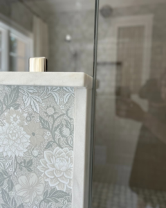 Close-up of decorative bathroom wallpaper and marble trim installed by Kevin Cradock Builders in Boston, MA.