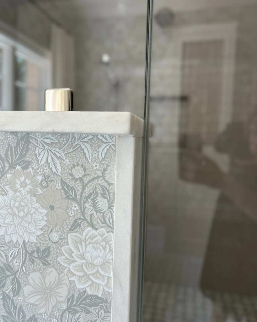 Close-up of decorative bathroom wallpaper and marble trim installed by Kevin Cradock Builders in Boston, MA.