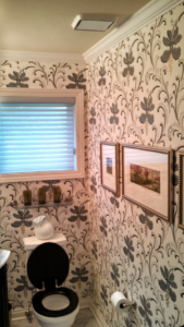 A newly wallpapered bathroom featuring elegant patterns, installed by Symphonic Painting in Oshkosh, WI.