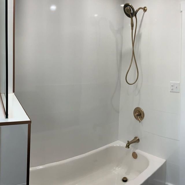 A close-up of a newly installed bathtub and shower fixture in a renovated bathroom by McIntyre's Renovations LLC in Pittsburgh, PA