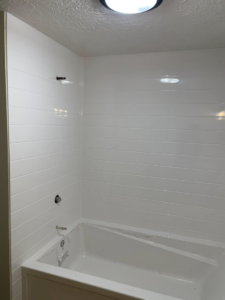 Bathtub and white wall panel installation in a bathroom by DeJean Home Renovation in Yankton, SD.