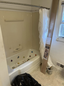 Bathtub area in a bathroom during renovation, with materials and a trash bag by JTL Contracting Services LLC in Inver Grove Heights, MN