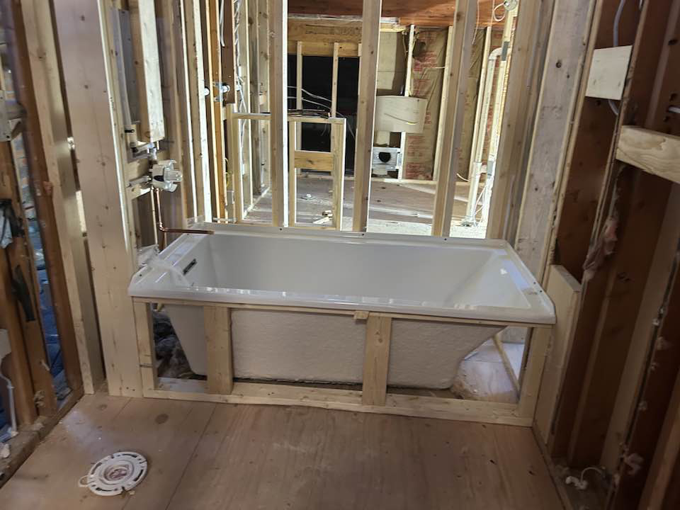 A new bathtub being installed within wooden framing by Haus Builders in Goodhue, MN