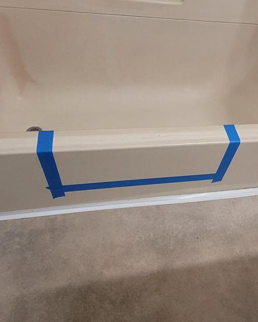 A bathtub with blue painter's tape marking the area for a tub modification, a service offered by Tupelo Handyman in Tupelo, MS.