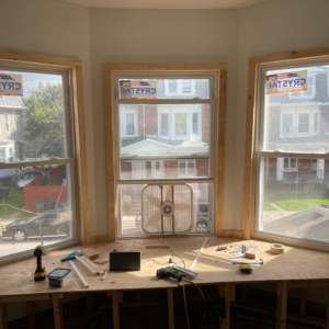 Bay window installation with new windows and unfinished wood trim by North Shore Construction & Renovation in Philadelphia, PA.