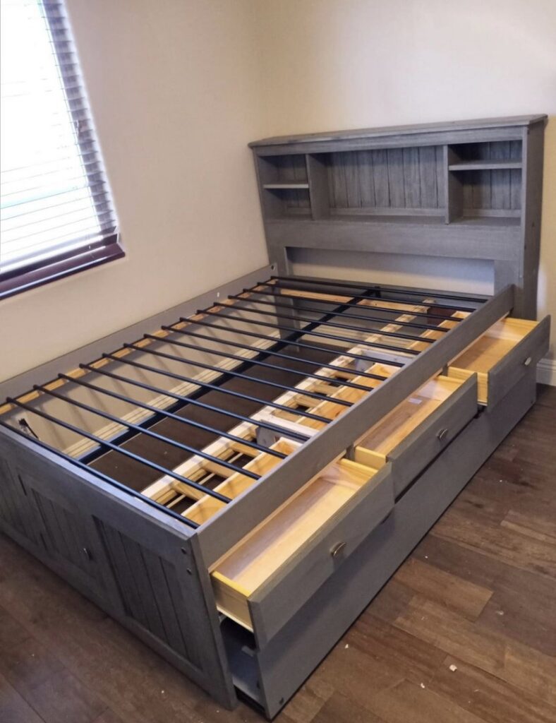 A grey bed frame with a headboard and under-bed storage drawers, fully assembled by Tech Handy-Las Vegas in North Las Vegas, NV.