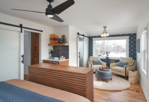 A bedroom with a custom-built bar, floating shelves, and a sliding barn door installed by EdgeWork Design Build in Minneapolis, MN.