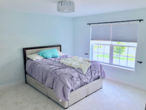 A bedroom with new window blinds and a ceiling light fixture installed by Handyman Helper in Simi Valley, CA.