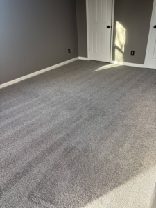 A newly carpeted bedroom with fresh gray paint, completed by DC Home Solutions in Atlanta, GA.