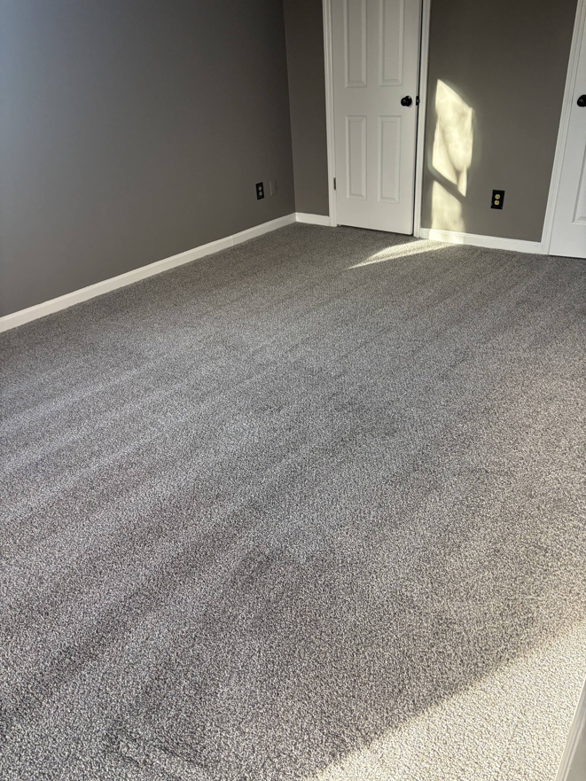 A newly carpeted bedroom with fresh gray paint, completed by DC Home Solutions in Atlanta, GA.