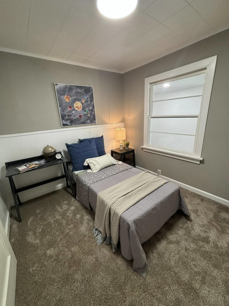 A furnished bedroom showcasing new carpet, wainscoting, and fresh paint by A to Z Remodeling llc in Gresham, OR.