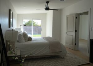 A modern bedroom with a newly installed black ceiling fan, part of a home improvement project by American Wolf Construction in Mesa, AZ