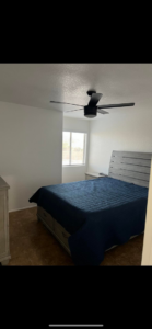A bedroom with a newly installed black ceiling fan and fresh paint by Arizona Contracting And Remodeling LLC in Tucson, AZ