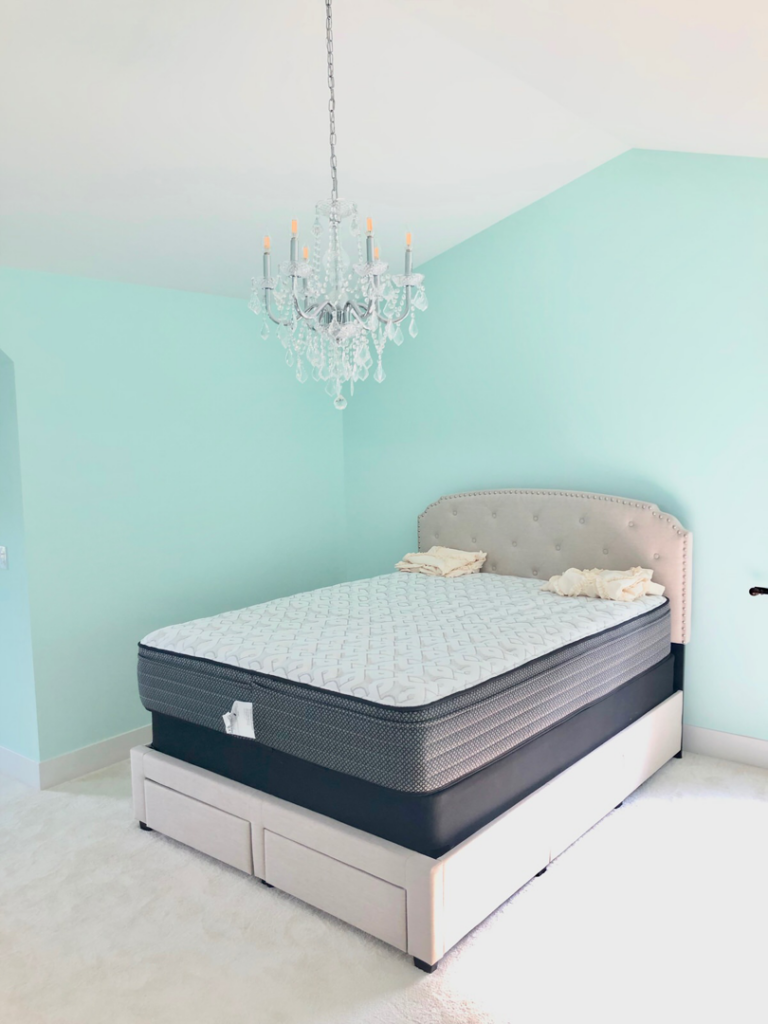 A bedroom with a new chandelier and freshly painted walls by Handyman Helper in Simi Valley, CA.