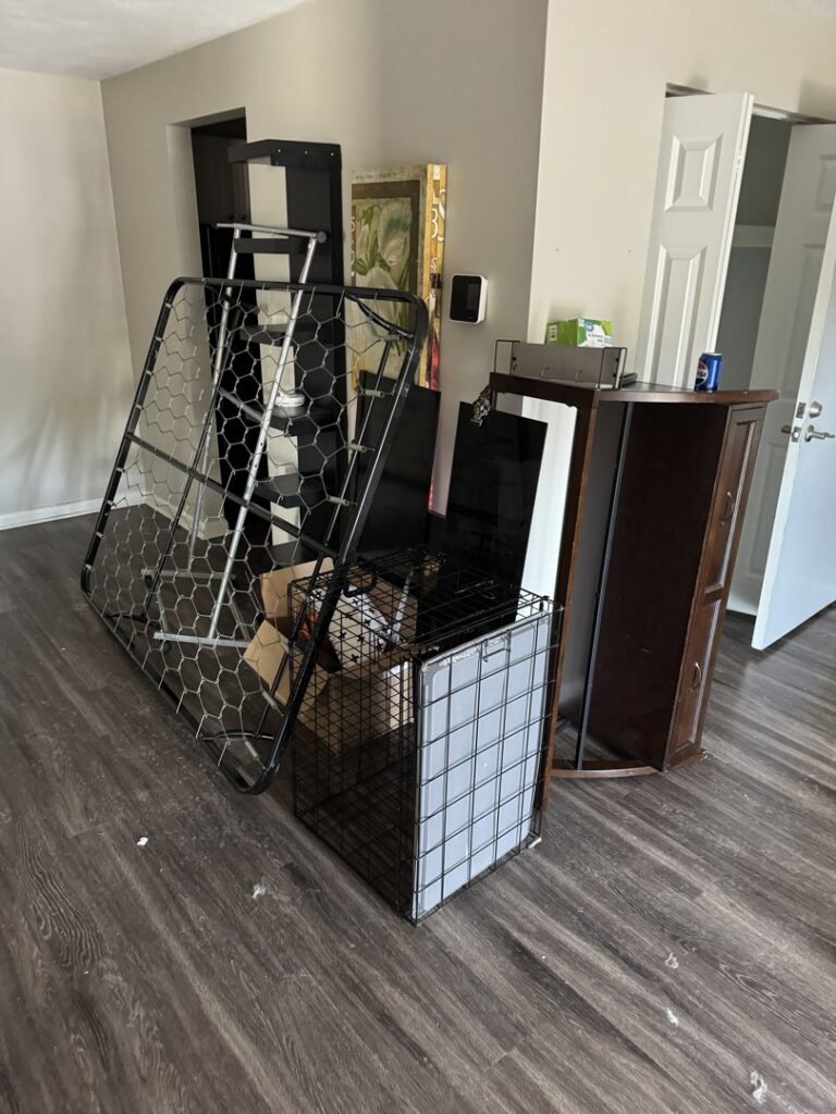 A room with a metal bed frame, cage, and other items, indicating a cleanout service by Junk Removal Brothers in Worcester, MA.