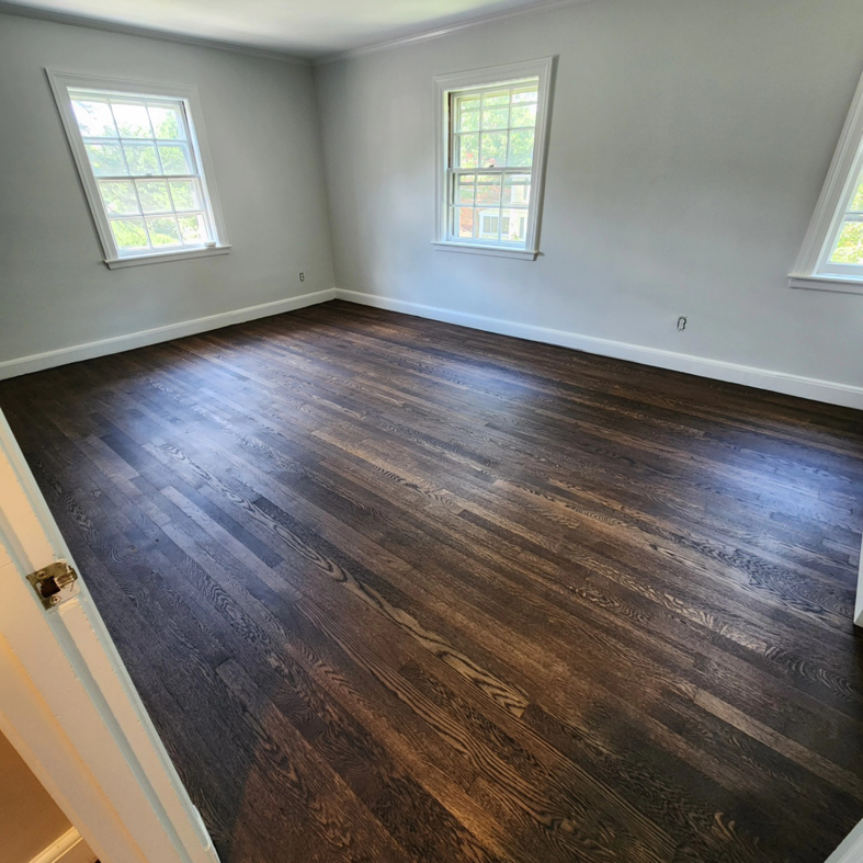 A bedroom featuring a new dark hardwood floor installation by floorzone.inc in Los Angeles, CA.