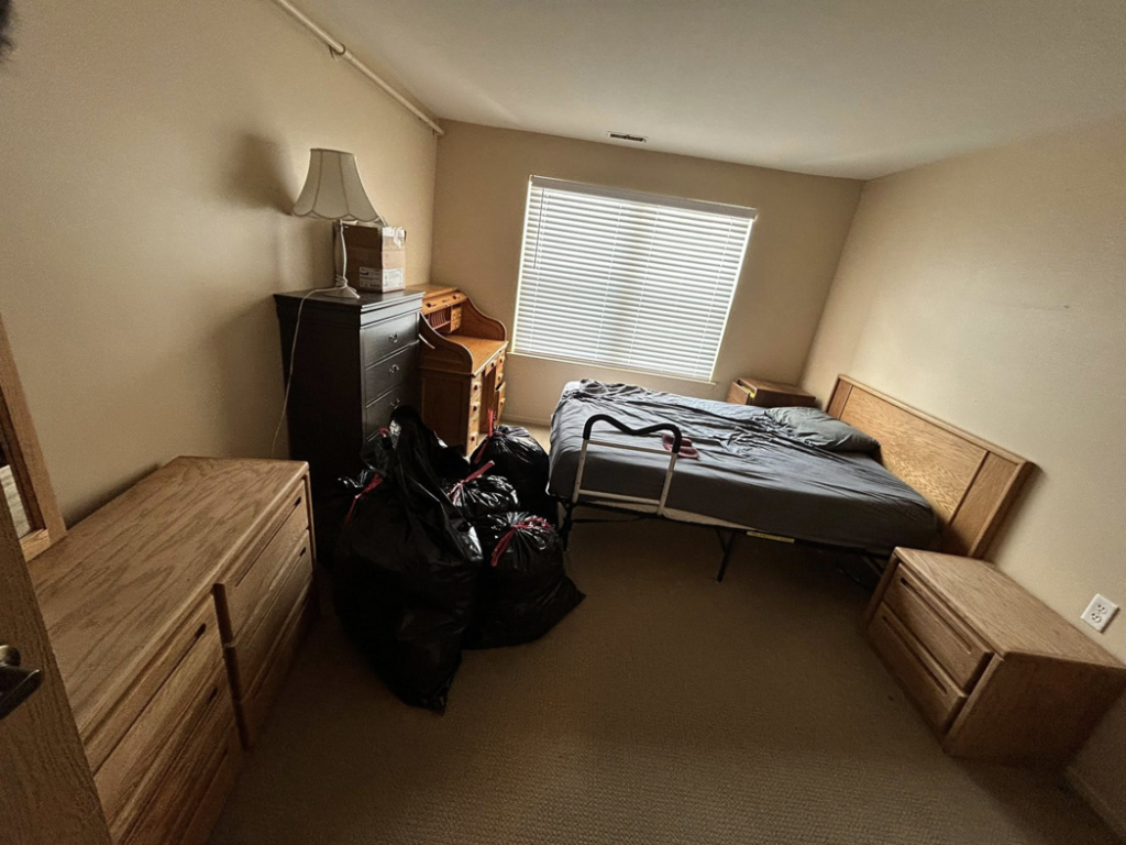 A bedroom with black trash bags and furniture, ready for junk removal by Big Joe's Junk removal Company LLC in Gibraltar, MI.