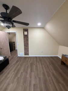 A renovated bedroom with new laminate flooring, a ceiling fan, and recessed lighting by T-N-T Mechanical in Westland, MI.