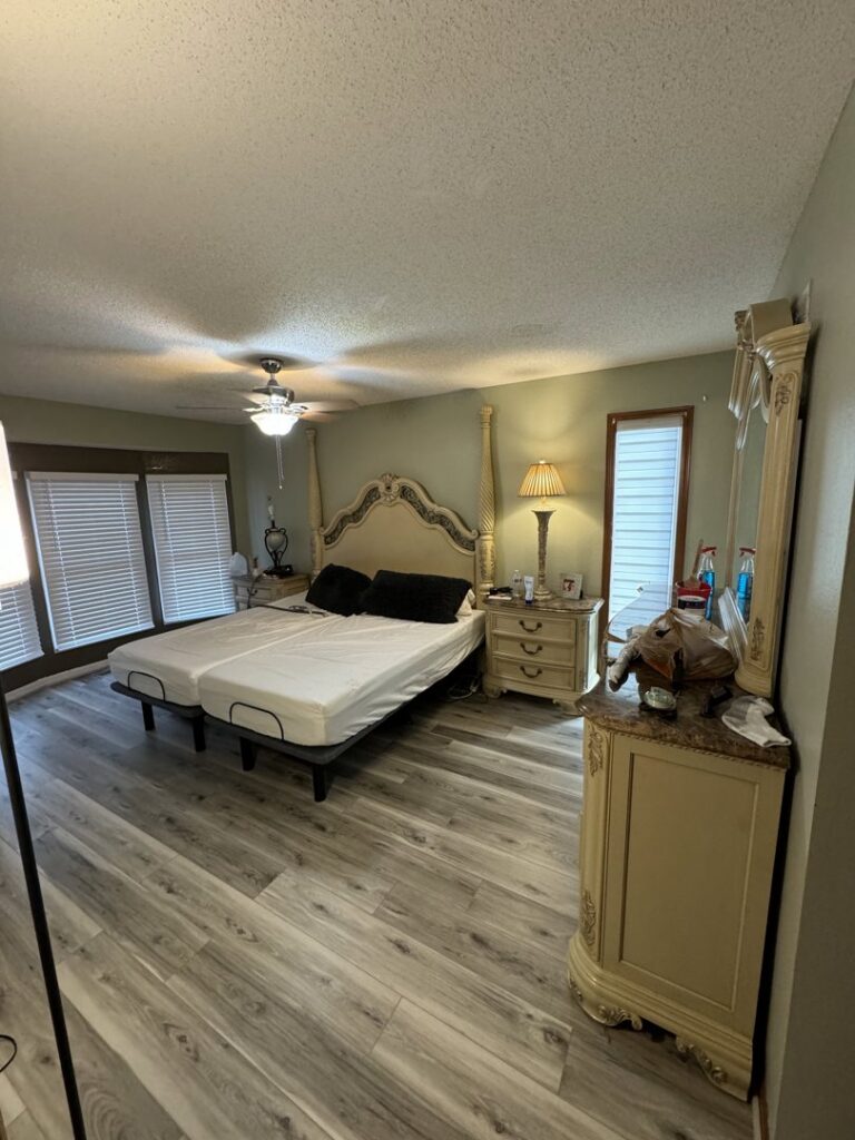 A bedroom with new LVP flooring recently installed by Gateway Home Services KC LLC in Kansas City, MO.