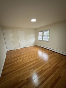 A bedroom featuring a pristine new hardwood floor installation by Shore Flooring Solutions in Edison, NJ.