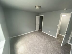 A newly painted bedroom with fresh grey carpet by Advanced Remodeling Services in Elbert, CO.