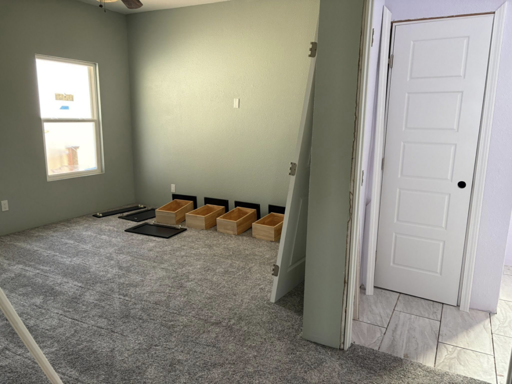 A bedroom renovation featuring new carpet and doors being installed by EJL Construction, LLC in Roswell, NM.
