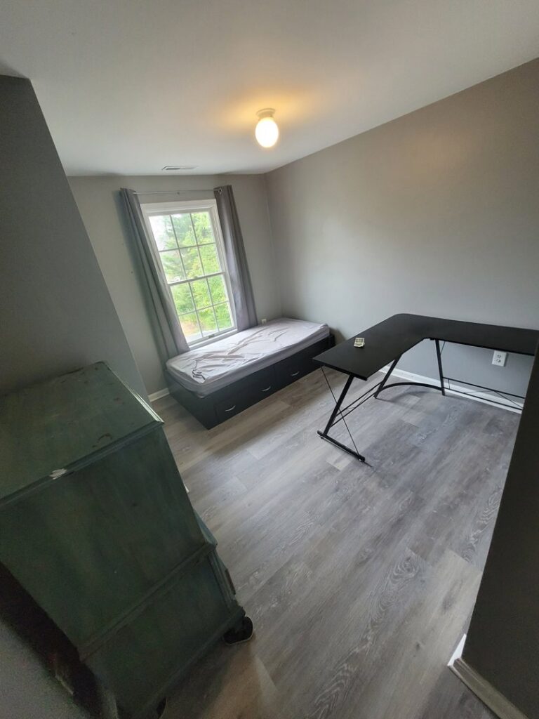 A newly renovated bedroom with new flooring and paint by Priority Property Services in Salisbury, MD.