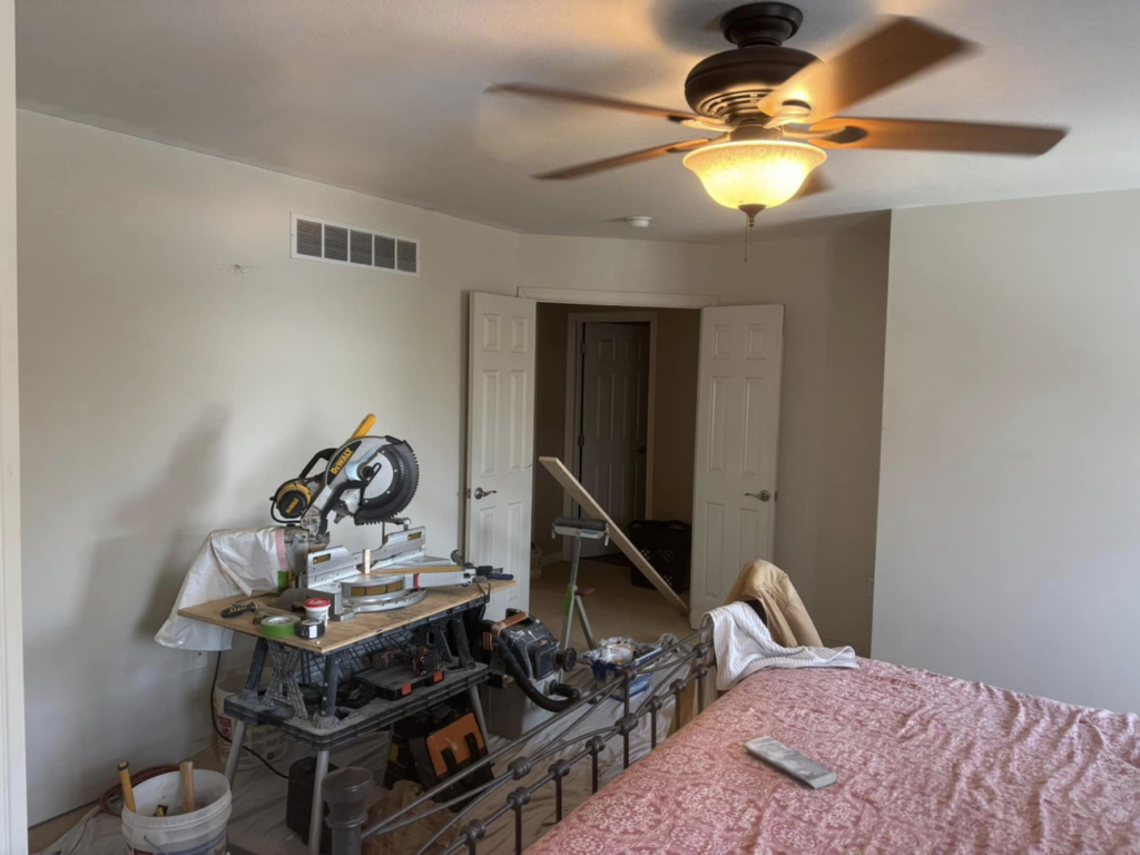 A bedroom undergoing renovation with a miter saw and tools set up by MLJ Construction and Design in Pittsburgh, PA