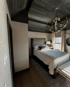 A modern bedroom featuring textured wallpaper and a dark wood ceiling installed by JU Wallpaper & Painting Services in Atlanta, GA.