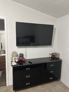A flat-screen television professionally mounted on a bedroom wall by K-Way's Handyman Services in Lincoln, NE