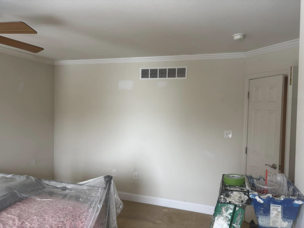 A bedroom wall with new crown molding and paint preparation, showcasing work by MLJ Construction and Design in Pittsburgh, PA