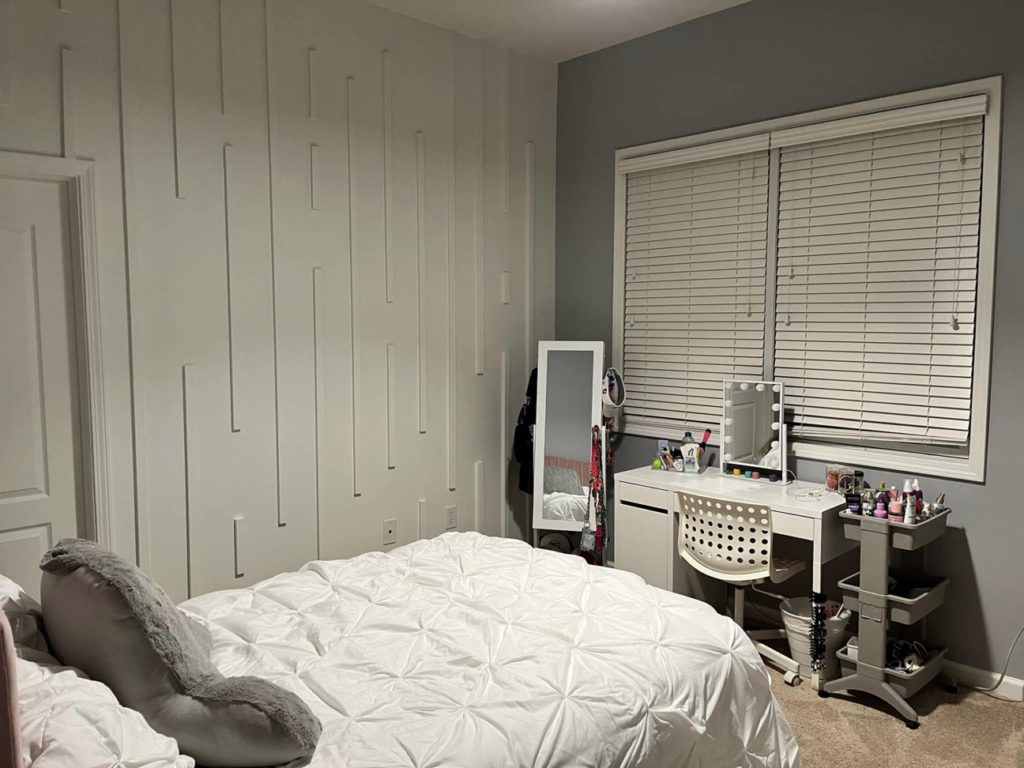 A modern white accent wall with vertical slat trim installed in a bedroom by Shawn's Handyman Services in Fishers, IN.