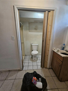 An old and worn basement bathroom with a toilet and sink before remodeling by Inside Out Commercial Solutions in Cleveland, OH.
